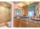 Bathroom with a marble countertop, tiled shower, and warm lighting at 27 Via Paradiso St, Henderson, NV 89011
