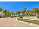 Gated community entrance featuring lush landscaping, palm trees, and a clear blue sky at 27 Via Paradiso St, Henderson, NV 89011