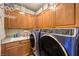 Laundry room featuring front loading washer and dryer, wooden cabinets, and counter space at 27 Via Paradiso St, Henderson, NV 89011