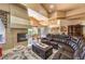 Spacious living room with a cozy fireplace, leather sectional sofa, and travertine flooring at 27 Via Paradiso St, Henderson, NV 89011