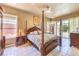 Luxurious main bedroom features a four-poster bed, ensuite bathroom, and sliding glass doors to the backyard at 27 Via Paradiso St, Henderson, NV 89011
