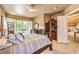 Comfortable main bedroom with a four-poster bed, ceiling fan, sliding glass doors and exterior fireplace at 27 Via Paradiso St, Henderson, NV 89011