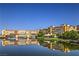 Beautiful waterfront view reflecting buildings on the calm water, with a clear blue sky above at 27 Via Paradiso St, Henderson, NV 89011