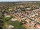 Aerial view overlooking a community with homes nestled alongside a golf course with mature trees and green fairways at 2816 Golfside Dr, Las Vegas, NV 89134