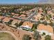 Expansive aerial view of a neighborhood featuring many tan-roofed homes and desert landscaping with mountain views at 2816 Golfside Dr, Las Vegas, NV 89134