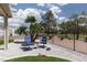 Backyard seating with neutral stone, turf, and views of lush palm trees at 2816 Golfside Dr, Las Vegas, NV 89134
