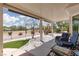 Covered patio with neutral stone and comfortable seating overlooks the well-manicured backyard at 2816 Golfside Dr, Las Vegas, NV 89134