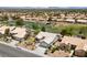 Beautiful aerial view of a well-maintained community with lush landscaping, pond, and golf course in the background at 2816 High Range Dr, Las Vegas, NV 89134