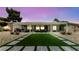 Backyard featuring a covered patio with stylish outdoor seating and dining area, with a well-kept lawn area at 2816 High Range Dr, Las Vegas, NV 89134