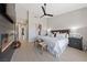 Light-filled primary bedroom with wood-look floors, ceiling fan, and a cozy fireplace at 2816 High Range Dr, Las Vegas, NV 89134