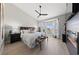 Spacious primary bedroom with a ceiling fan, wood floors, and a fireplace feature wall at 2816 High Range Dr, Las Vegas, NV 89134