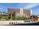 Stunning exterior view of Red Rock Casino with meticulously landscaped grounds and palm trees under a clear blue sky at 2816 High Range Dr, Las Vegas, NV 89134
