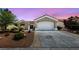 Inviting single-story home boasts a well-kept front yard with desert landscaping, an attached two-car garage, and neutral tones at 2816 High Range Dr, Las Vegas, NV 89134