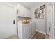 Bright laundry room with white washer, dryer, cabinets, and a charming gallery wall at 2816 High Range Dr, Las Vegas, NV 89134