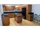 Spacious kitchen featuring brown cabinets, black countertops, and a functional center island at 3020 Wilmington Way, Las Vegas, NV 89102