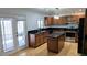 Well-lit kitchen showcasing brown cabinets, black countertops, and stainless steel appliances at 3020 Wilmington Way, Las Vegas, NV 89102