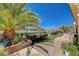 Landscaped backyard featuring mature palm trees, brick planter boxes, and a stone patio at 3112 Haddon Dr, Las Vegas, NV 89134