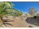 Spacious backyard with desert landscaping, a fire pit, and mature palm trees at 3112 Haddon Dr, Las Vegas, NV 89134