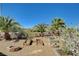A desert-landscaped backyard has trees, greenery, and stone beds, a serene retreat for relaxation and entertainment at 3112 Haddon Dr, Las Vegas, NV 89134