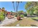 The backyard showcases a covered patio, lush landscaping and mature trees at 3158 La Luna Cir, Henderson, NV 89014