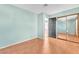 A simple bedroom with light green walls, wood floors, and a mirrored closet at 3158 La Luna Cir, Henderson, NV 89014