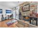 Cozy living room featuring a floor-to-ceiling stone fireplace and sliding door access to the patio at 3158 La Luna Cir, Henderson, NV 89014