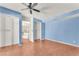 Bedroom featuring hardwood floors, blue walls, closet, and access to the attached bathroom at 3158 La Luna Cir, Henderson, NV 89014