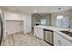 Bright kitchen showcases stainless dishwasher, white cabinets, and view to an adjacent living area at 3400 Cabana Dr # 1048, Las Vegas, NV 89122