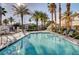 Resort-style community pool featuring clear water and lush landscaping with swaying palms and ample seating at 3400 Cabana Dr # 1048, Las Vegas, NV 89122