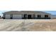 Single story home with a gray exterior, a three car garage, and desert landscaping at 3791 Soplo Rd, Pahrump, NV 89048