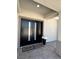 Modern black double front door with a welcome mat and potted flowers on a tiled entryway at 3791 Soplo Rd, Pahrump, NV 89048
