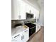 Well-lit kitchen features white cabinets, stainless steel appliances, and marble countertops at 3791 Soplo Rd, Pahrump, NV 89048