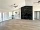 Open living room with hardwood floors, ceiling fans, and a modern black fireplace at 3791 Soplo Rd, Pahrump, NV 89048