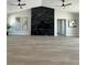 Bright living room with a modern fireplace, ceiling fans, and light hardwood floors at 3791 Soplo Rd, Pahrump, NV 89048