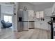 Modern kitchen featuring stainless steel appliances, white cabinets, and wood-look flooring at 394 Lombardy Cir, Henderson, NV 89015