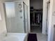 Elegant bathroom featuring a glass-enclosed shower and a peek into a walk-in closet at 411 Hellebores Ave, North Las Vegas, NV 89084