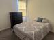 Well-lit bedroom featuring a bed, nightstand, and a window allowing natural light at 411 Hellebores Ave, North Las Vegas, NV 89084