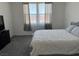 Bedroom with grey carpet, tv atop the dresser, and a window with privacy blinds at 411 Hellebores Ave, North Las Vegas, NV 89084