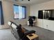 Cozy living room area featuring a large flat-screen TV, comfortable seating, and a work space at 411 Hellebores Ave, North Las Vegas, NV 89084
