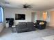 Spacious living room with a large-screen TV, comfortable seating, and a ceiling fan at 411 Hellebores Ave, North Las Vegas, NV 89084
