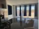 Bright living area off kitchen with large sliding glass door and dark curtains at 411 Hellebores Ave, North Las Vegas, NV 89084