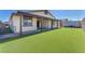 Backyard with artificial turf and covered patio extending along the rear of the home at 4510 Rubious Ave, North Las Vegas, NV 89084