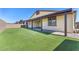 Backyard with artificial turf and covered patio extending along the rear of the home at 4510 Rubious Ave, North Las Vegas, NV 89084