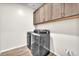Functional laundry room with modern washer/dryer units and ample overhead cabinet space at 4510 Rubious Ave, North Las Vegas, NV 89084