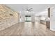 Open living area with modern finishes, including a stone accent wall, wood-look floors, and sliding glass doors at 4510 Rubious Ave, North Las Vegas, NV 89084
