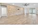 Spacious living room featuring wood-look tile flooring, a stone accent wall, and ample natural light at 4510 Rubious Ave, North Las Vegas, NV 89084