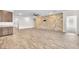 Open-concept living area with a stacked stone wall, ceiling fan, and wood-look flooring at 4510 Rubious Ave, North Las Vegas, NV 89084