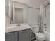 Bathroom features a vanity with sink, a large mirror, a toilet, and a shower with a shower curtain at 4622 English Lavender Ave, North Las Vegas, NV 89031