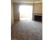 Spacious living room with plush carpeting, fireplace, and bright patio doors at 5220 Mission Carmel Ln # 207, Las Vegas, NV 89107