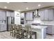 Modern kitchen featuring gray cabinets, granite countertops, and stainless steel appliances and a large island at 5328 Hickory Tree St, Las Vegas, NV 89149